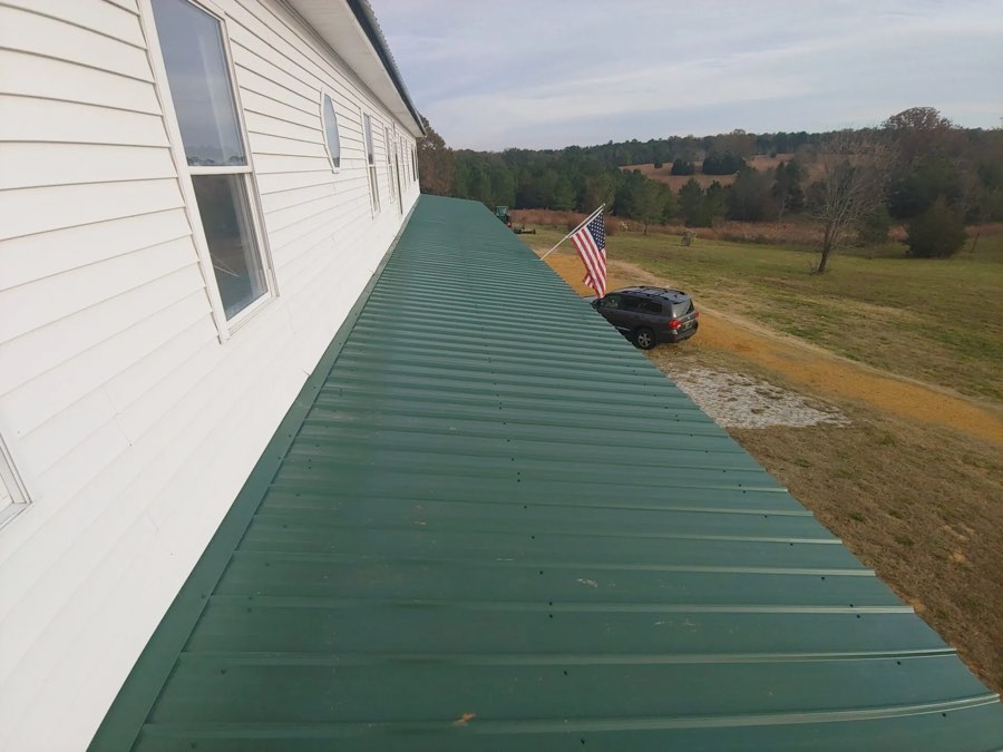 Green standing-seam metal roof on a farmhouse