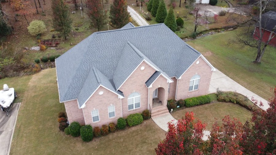 Drone view of a completed architectural shingle roof on a brick home