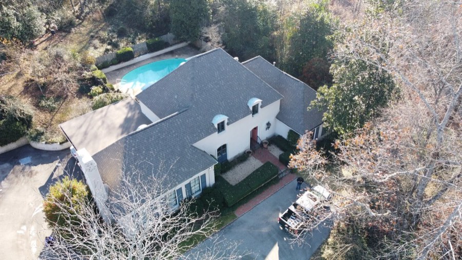 Completed shingle roof on a home with a pool, drone view